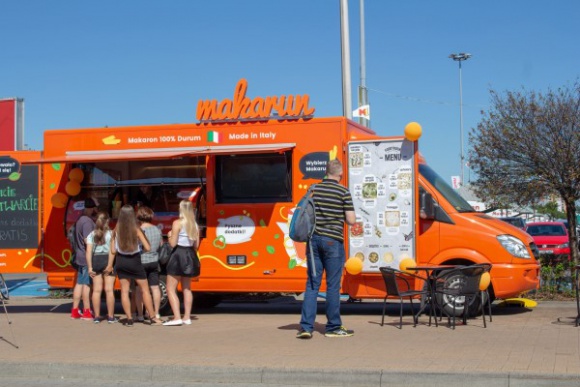 Trafiona lokalizacja makarunowego Food Trucka BIZNES, Firma - Pomarańczowy punkt, który z daleka widać pod krakowską galerią M1 to Food Truck marki Makarun Spaghetti and Salad. Błyszczący nowością mercedes serwuje jej klientom włoskie pasty na wynos.